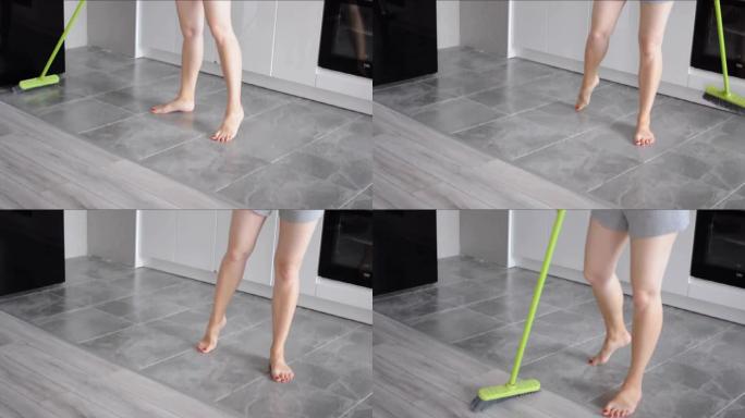 特写女人的腿用扫帚扫地