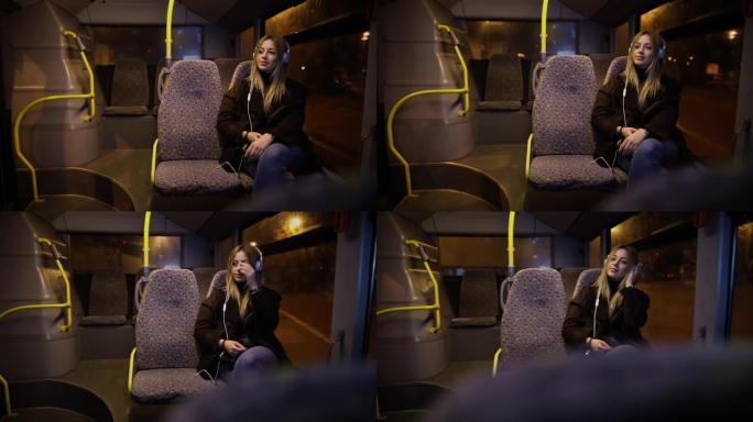 晚上乘公共汽车旅行时听音乐的女乘客。晚上，女孩在窗户旁边的行驶车辆上听音乐