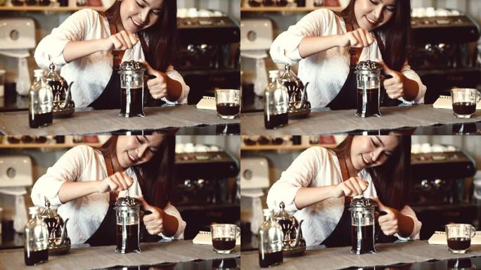 亚洲专业女咖啡师作为店主在自助餐厅的柜台酒吧用拿铁艺术咖啡倒牛奶。煮咖啡的女服务员。人们的生活方式和