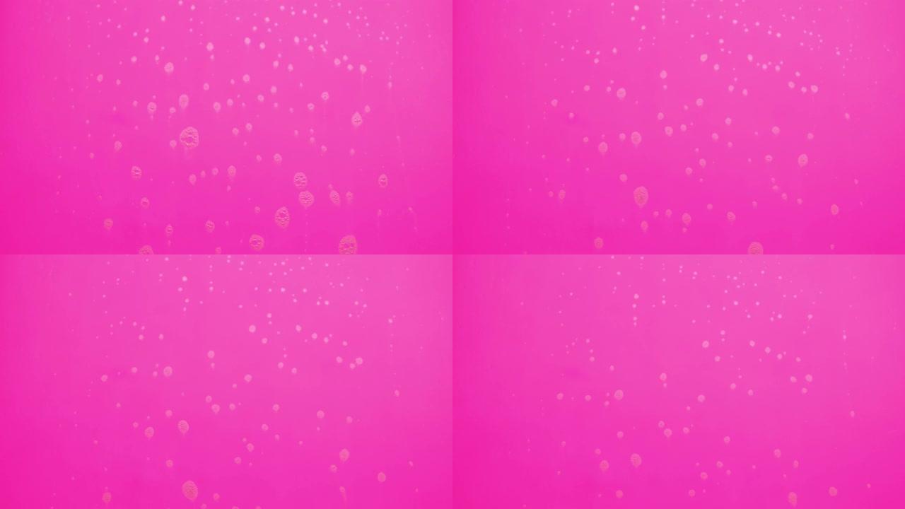 泡沫泡沫从肥皂流动在粉红色的背景。