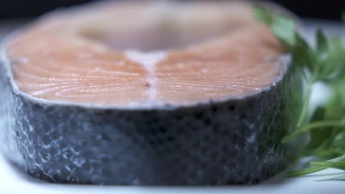 旋转新鲜鲑鱼排的盘子。大西洋鲑鱼切成绿色