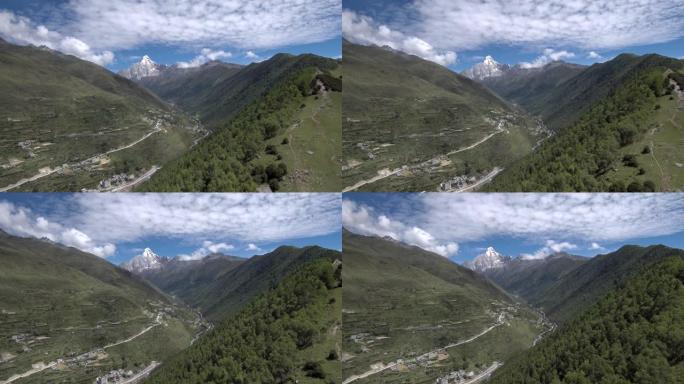 缓慢的无人机飞向山。四姑娘山 (四姑娘山)，山谷中有一个藏族小村庄 (四姑娘山)。在前往海子谷 (海