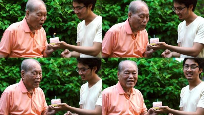 孙子手持的亚洲高级吹蜡烛，户外