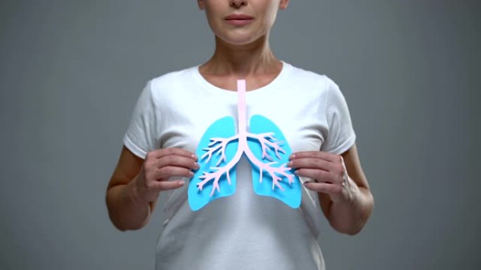 女士手持纸肺标志，预防癌症和结核病，保健