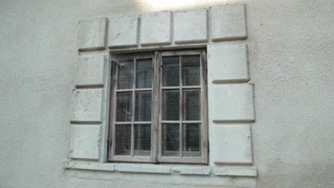 旧的木窗，在灰色的破旧建筑上，围绕着蜘蛛网和泥土
