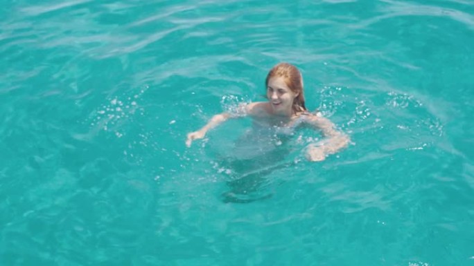 美丽的年轻女子在豪华雅赫附近的福门特拉或伊维萨群岛附近的清澈蓝色水中游泳