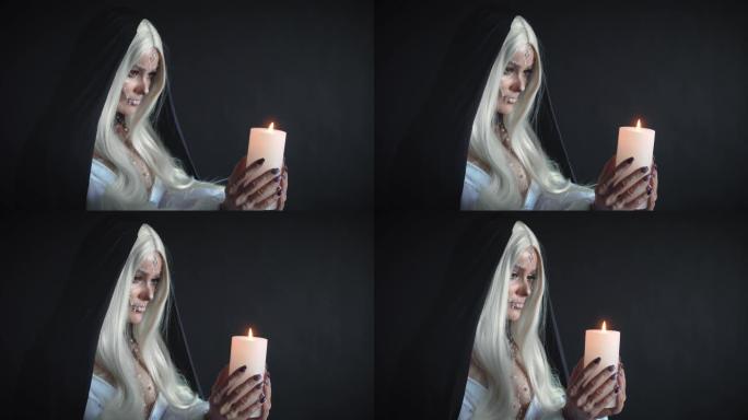 有着长长的白发和头上黑色兜帽的邪恶女巫手里拿着蜡烛