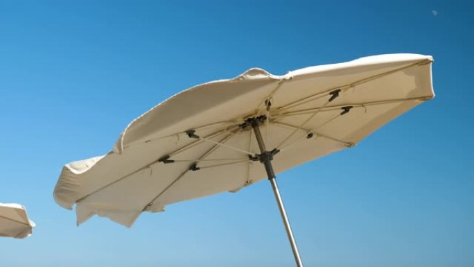 科斯塔德尔马雷斯梅海岸。太阳伞在强风中挥舞的特写镜头。西班牙。4K