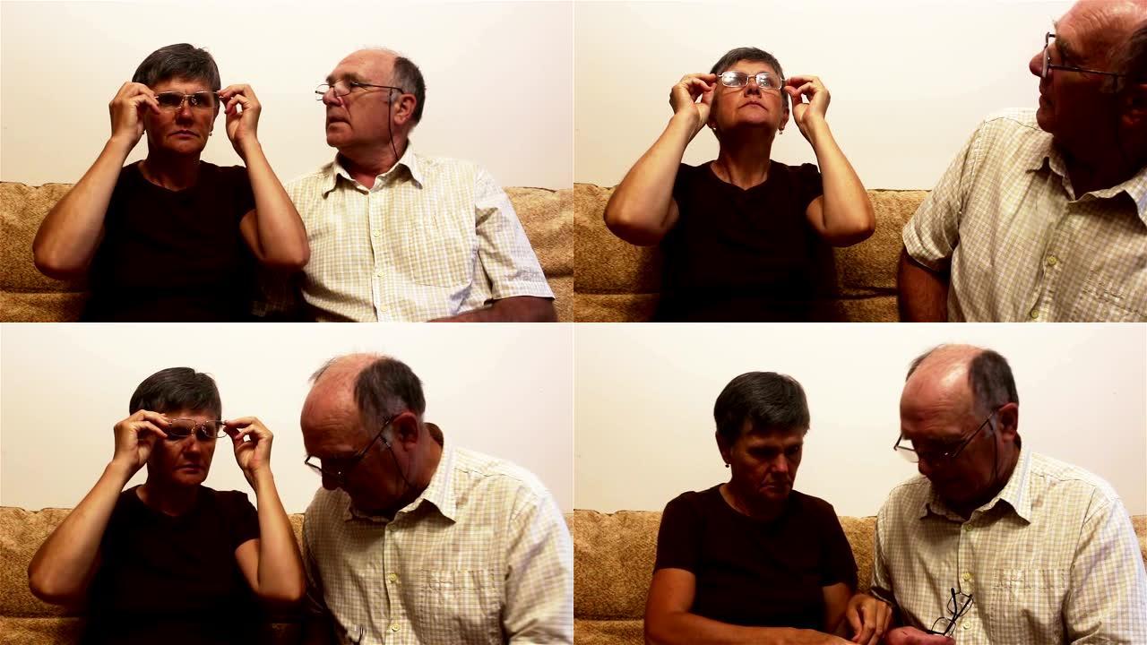 一对老年夫妇坐在家里的沙发上，试着戴眼镜看视力，互相咨询。