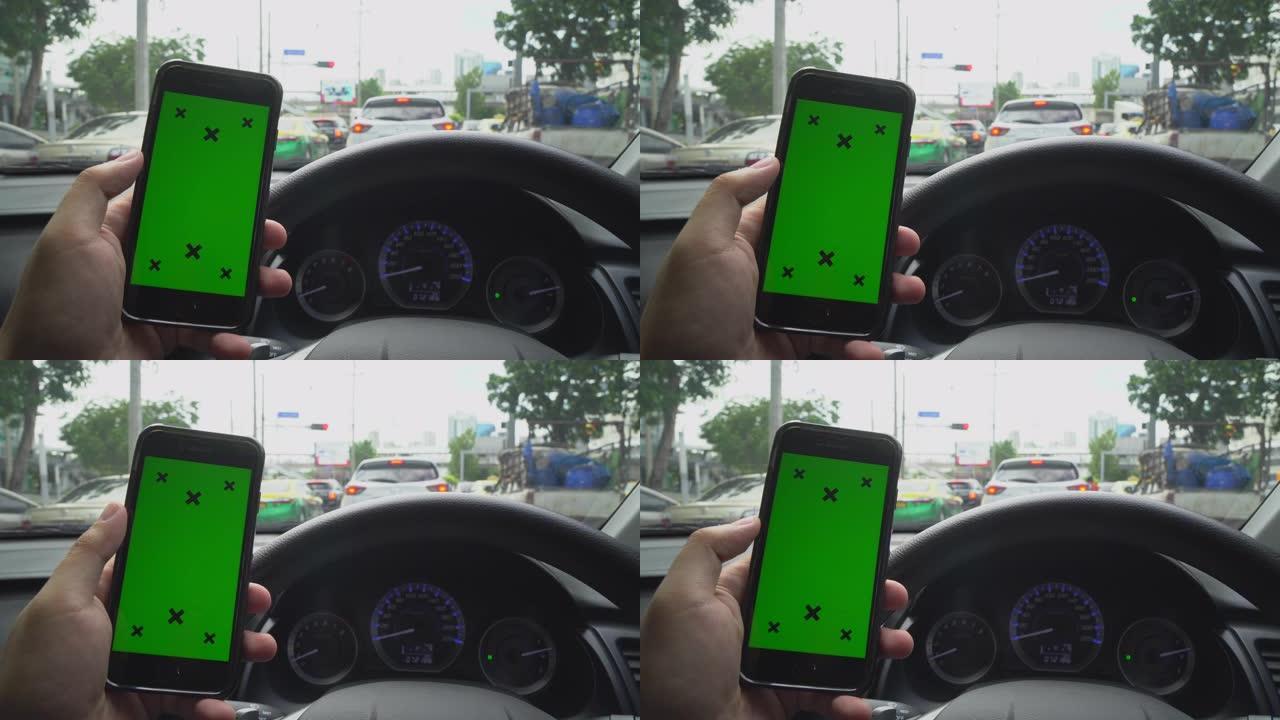 手持智能手机的特写镜头，看着汽车上的绿屏色度键显示。使用手机通过滚动、滑动、手指触屏。