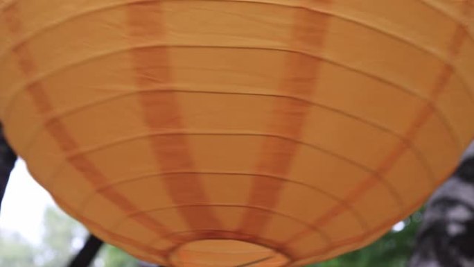 彩色传统橙色纸灯笼挂在户外，节日装饰品概念在风中摇摆