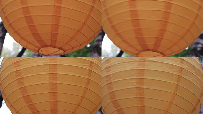 彩色传统橙色纸灯笼挂在户外，节日装饰品概念在风中摇摆