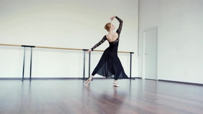 穿着黑色蕾丝紧身衣、长裙和尖头鞋的专业芭蕾舞演员在芭蕾舞工作室排练舞蹈