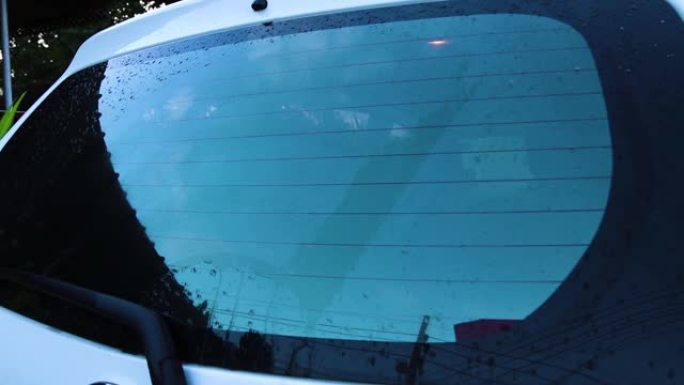 带雨滴和无框雨刮片特写的汽车挡风玻璃