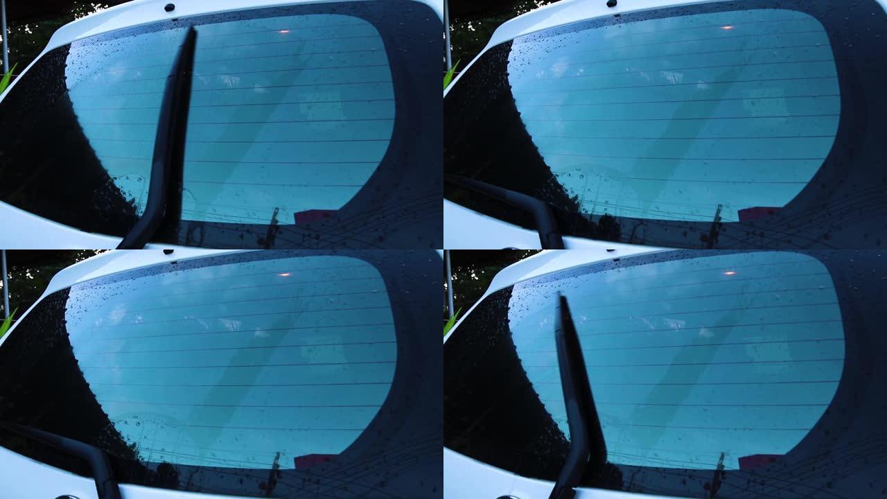 带雨滴和无框雨刮片特写的汽车挡风玻璃