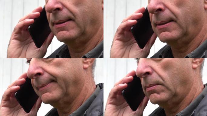 一名中年男子的特写嘴唇在黑色智能手机中说了些什么