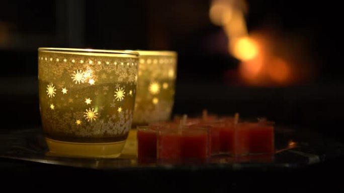 4k圣诞装饰蜡烛和背景壁炉与咆哮的火