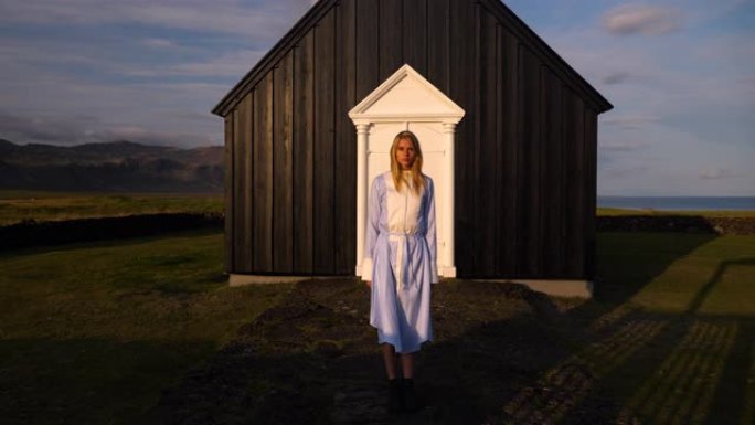 一个年轻女孩探索冰岛的一座黑人教堂。童话时尚故事