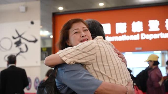 中国高级夫妇在机场起飞时拥抱