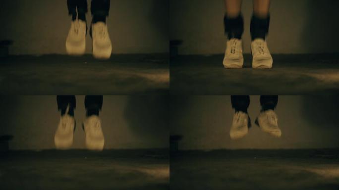 穿着白色运动鞋和黑色脚踝重量的腿部特写镜头，做跳跃运动，增加身高和耐力。