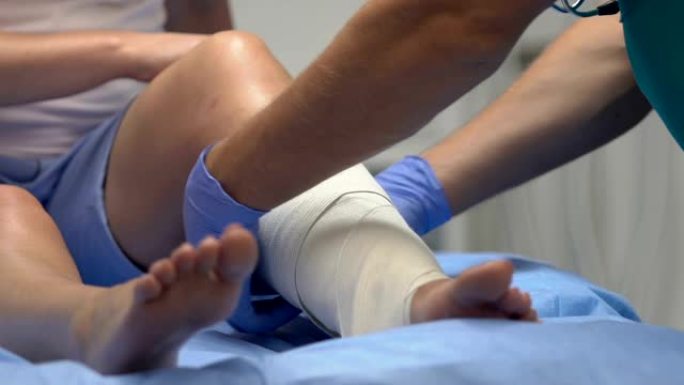创伤专家在受伤的患者腿上佩戴弹性绷带，创伤结果