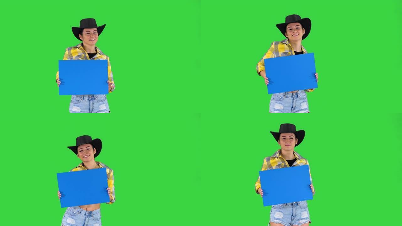 微笑的漂亮女牛仔拿着空木板，在绿色屏幕上跳舞，蓝色模型