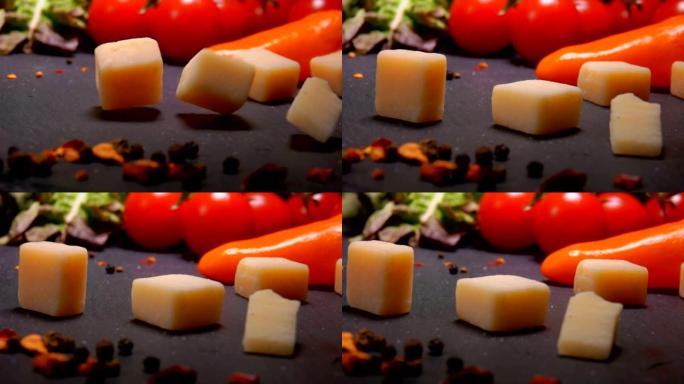硬奶酪块掉落在带有胡椒粉的黑色表面上