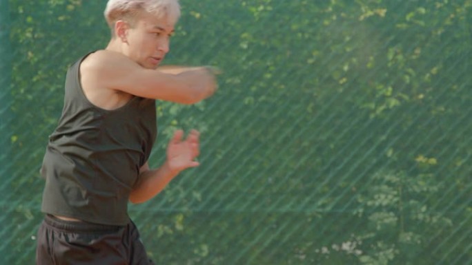 一名年轻的混血网球运动员以慢动作强力抽射网球。