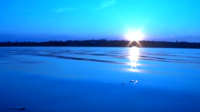 夏季日落在平静的河流上，镜头曝光效果