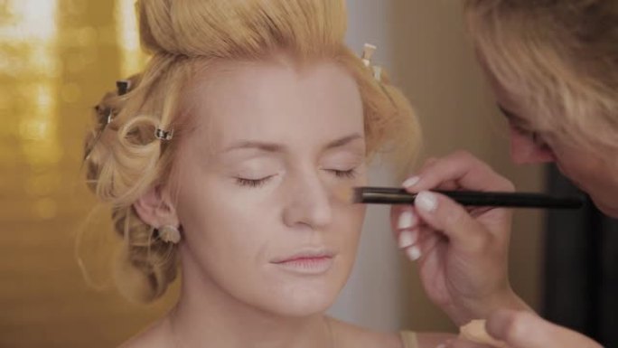 专业化妆师将模特的化妆照片应用于女性