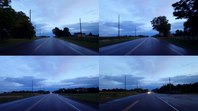 开车穿过乡村，接近地平线上的城市灯光。驾驶视点POV在白天驶向城市极限。