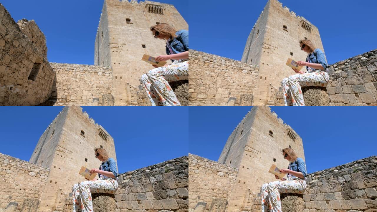 女人正在检查位于塞浦路斯Kolossi城堡附近的旅游手册