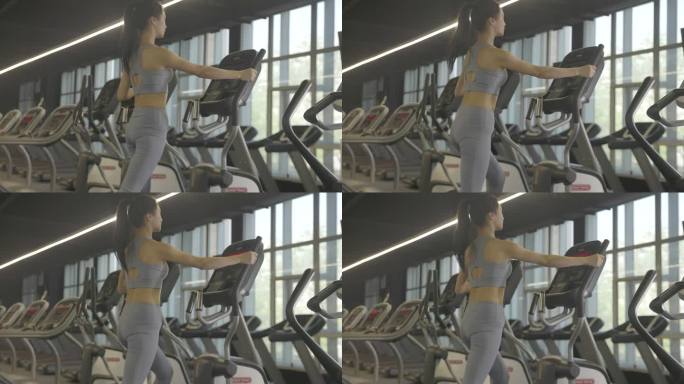 运动装女性在健身房使用器材锻炼