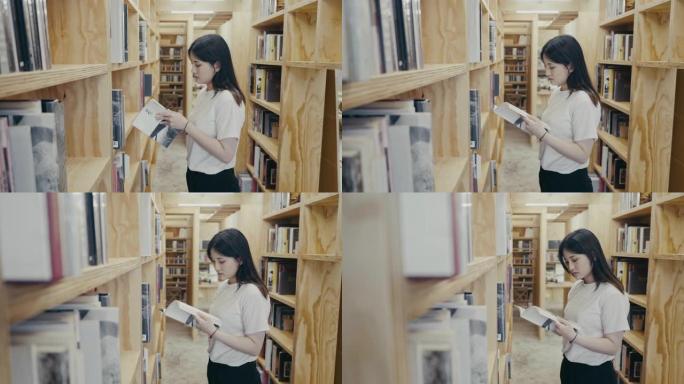 年轻的亚洲大学生在图书馆里找书 (慢动作)