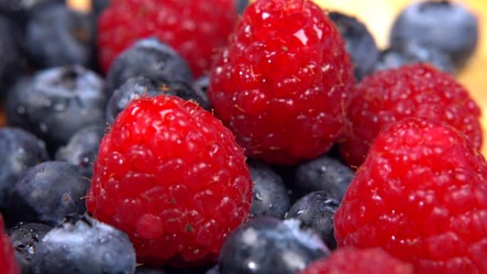 在4k中旋转的彩色新鲜森林浆果的特写镜头。各种健康的浆果，蓝莓和覆盆子的营养特性。自制果汁的成熟浆果