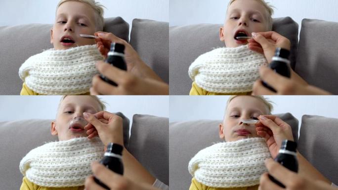 有爱心的妈妈给咳嗽糖浆生病的男孩子戴围巾，喉咙痛治疗
