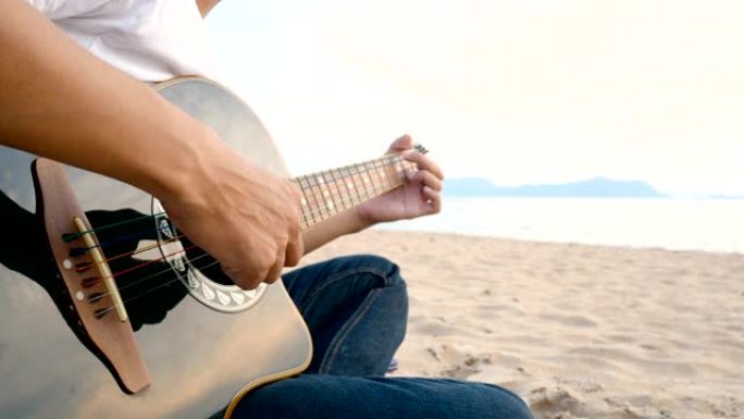 4K。日落时分，一个男人在海滩上弹奏原声吉他，感觉放松