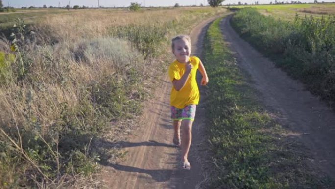 一个女孩在田野里沿路奔跑。穿着黄色t恤的有趣女孩
