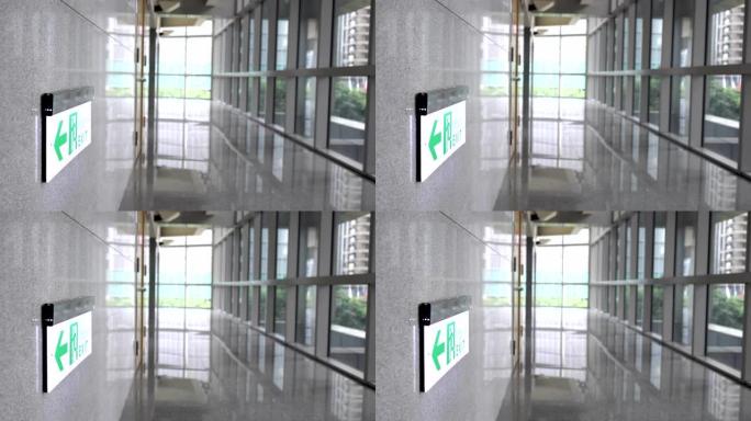 紧急出口，逃生路线标志。公共场所现代建筑中的位置。四个汉字表示紧急出口。模糊的背景是透明的窗户。