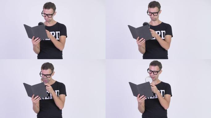 快乐的书呆子男人戴眼镜阅读书籍和使用放大镜