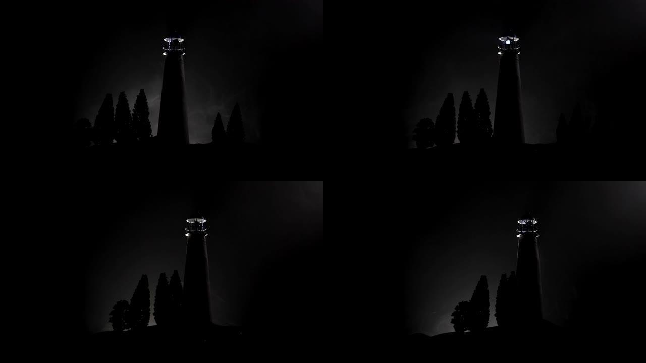 夜晚有雾的光束灯塔。矗立在山上的老灯塔。桌子装饰。色调背景。月光照明。选择性聚焦