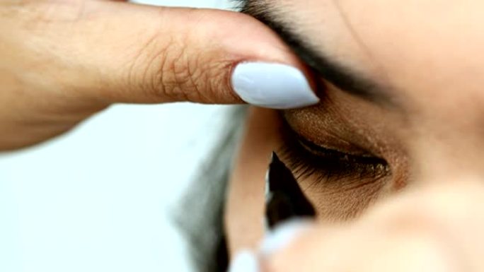 女人用眼线笔化妆美容