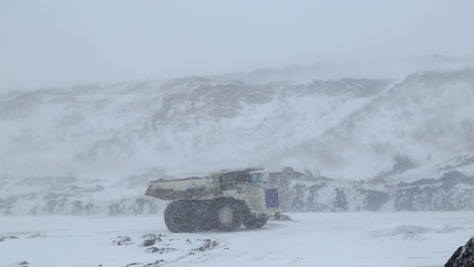 一辆翻车车在冬季驶过露天煤矿