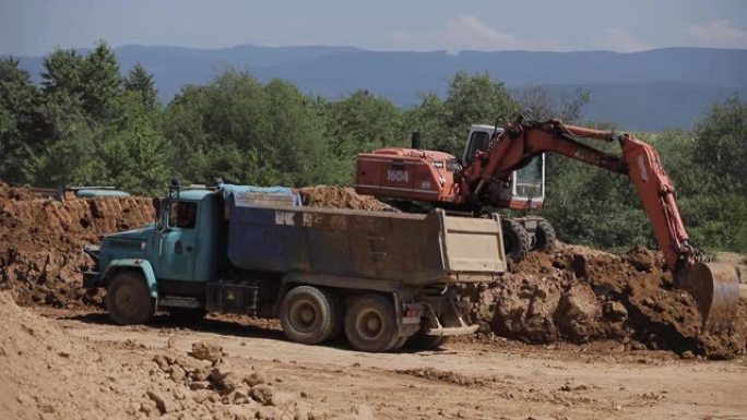挖掘机挖煤并将其倒入大型自卸车中