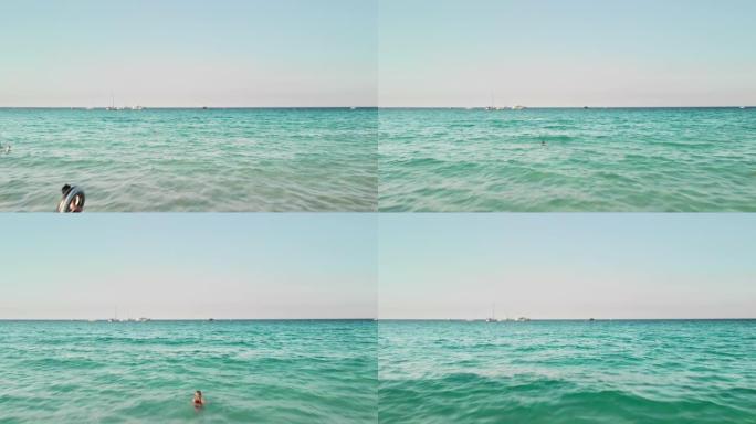 无法识别的女孩游客带着充气游泳圈进入大海。暑假概念。在公海游艇的背景下。空中无人机射击