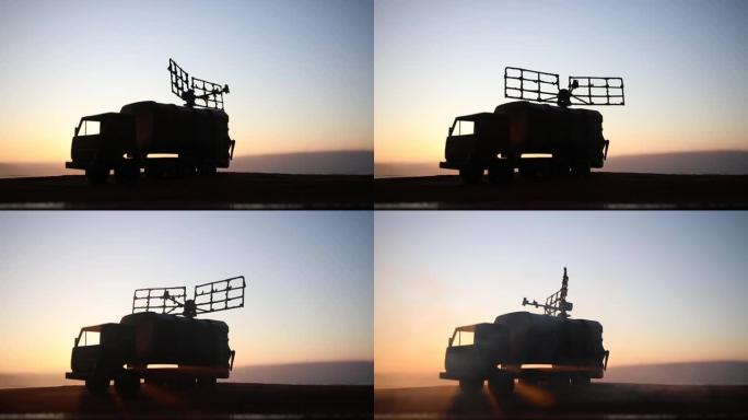 创意艺术品装饰。日落时带雷达天线的移动式防空卡车的轮廓。卫星天线或无线电天线对着夜空。选择性聚焦