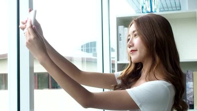 美容亚洲女人使用智能手机聊天，网上购物，拍照感觉快乐快乐