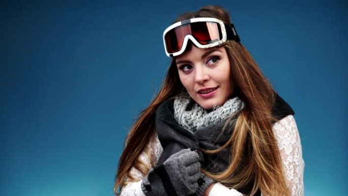 穿着暖和衣服的微笑滑雪女孩滑雪护目镜。