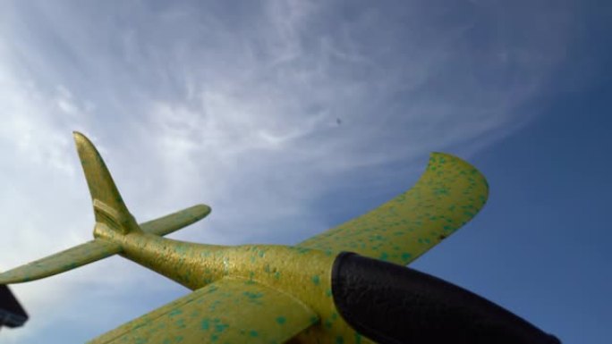 玩具飞机的特写镜头被蓝天中的真实飞机取代。