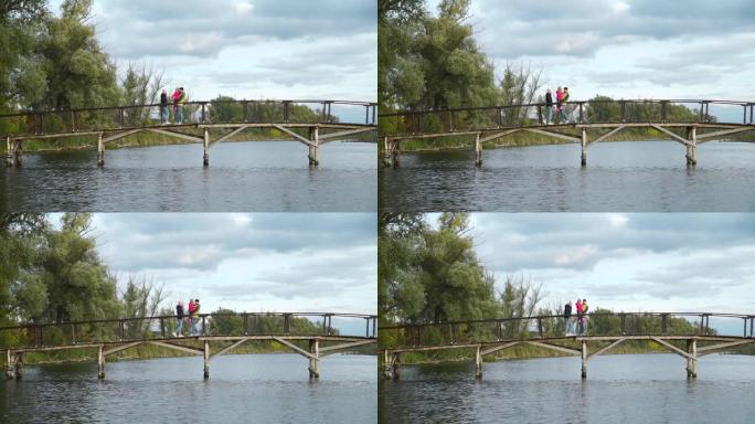 一家人沿着湖边的木桥行走